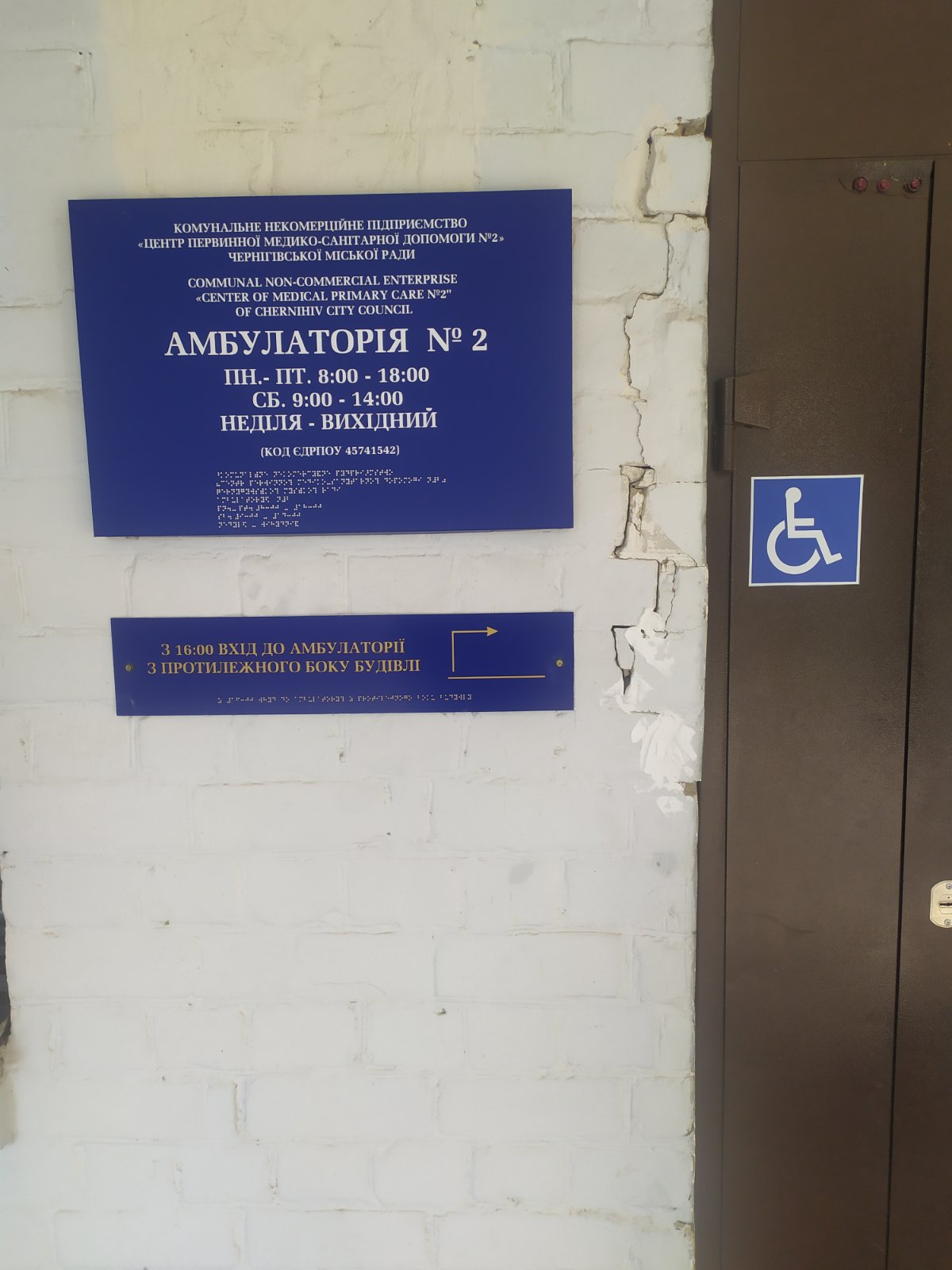Вхід до амбулаторії з табличкою Брайля та позначкою доступності